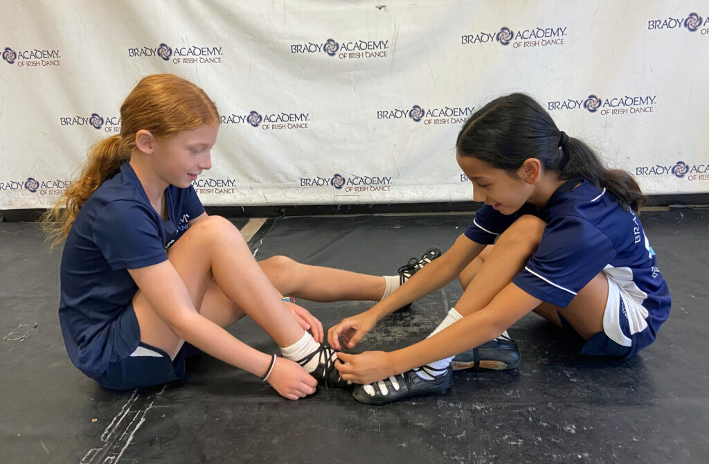 Two Young Irish Dancers Putting Dance Shoes On